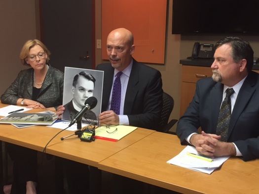 Attorneys Patrick Noaker, center, holding a portrait of the Rev. John Huchthausen, and Marci Hamilton, left, and Leander James.