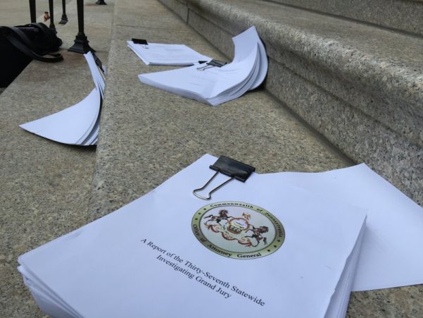 Clergy sexual-abuse grand-jury reports were strewn on the steps leading into the Cathedral Basilica of Saints Peter and Paul during Monday afternoon's press conference.