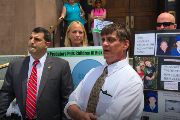John-Michael Delaney, outspoken clergy sex-abuse victim, was supposed to meet with Archbishop Charles Chaput on Monday. Instead, state Rep. Mark Rozzi (left) flew him to Philadelphia to participate in a protest after that meeting was canceled. Behind Delaney stands sexual-abuse victim Kristen Pfautz Woolley.